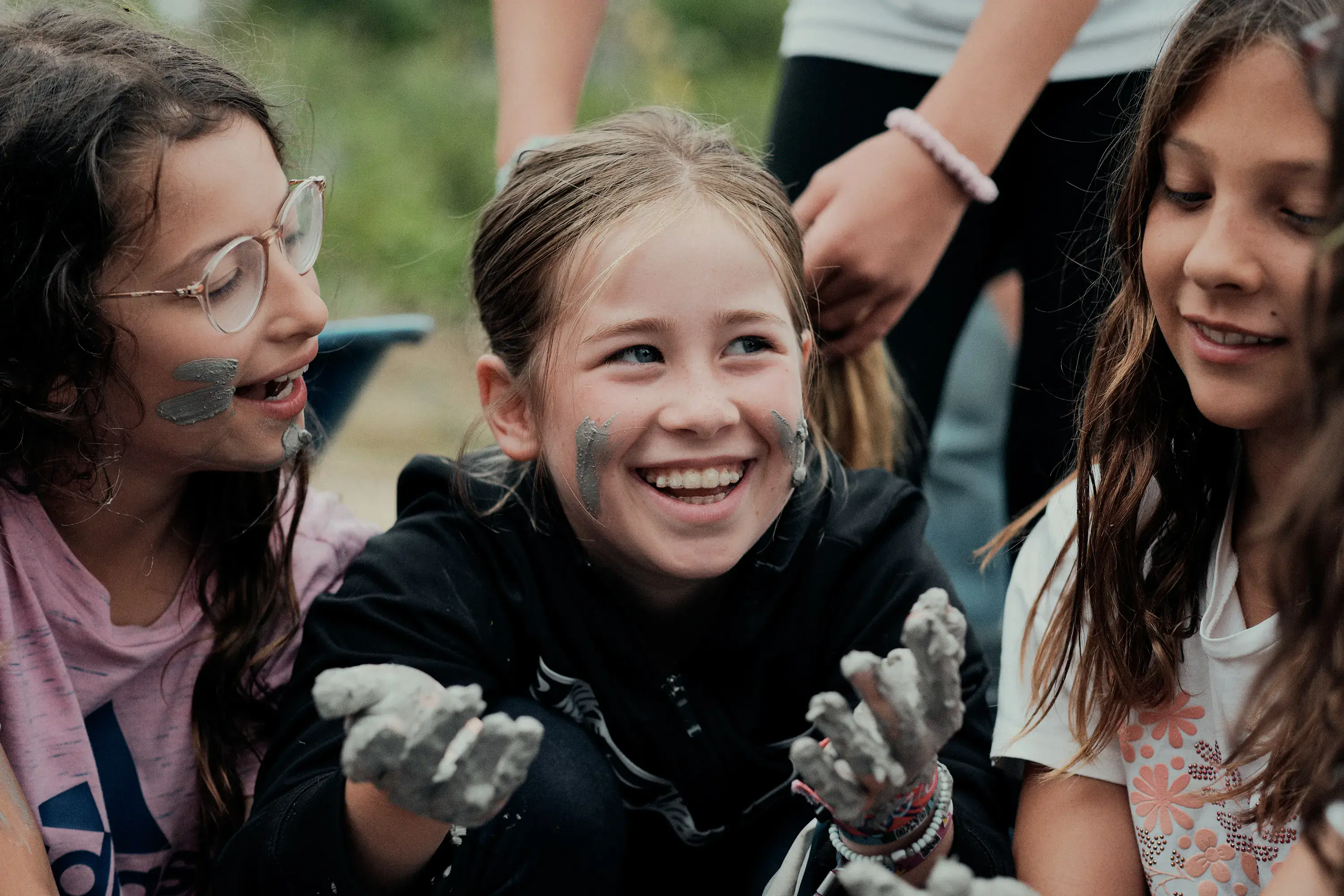 3 kids playing with mud
